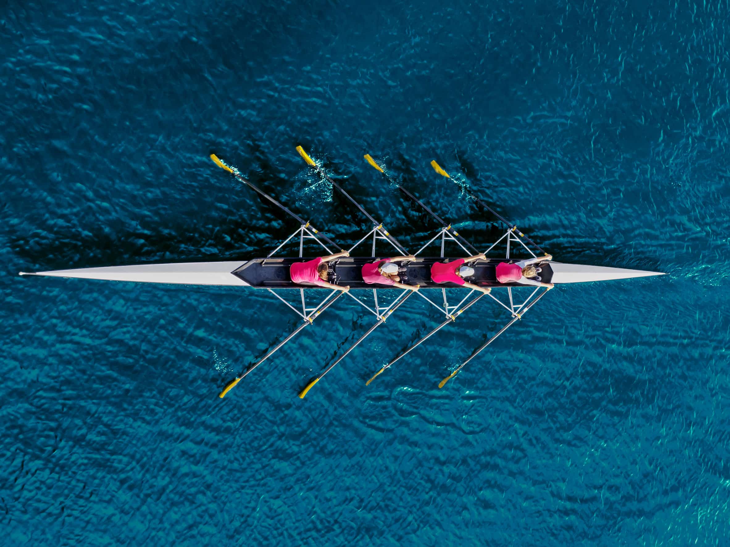synchronized team boat rowing in ocean